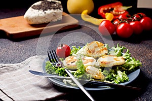 Halloumi cheese, grilled, with lettuce salad, cherry tomates and herbs