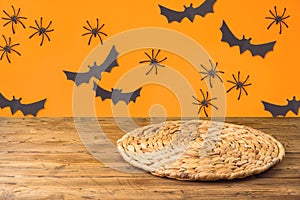 Halloweeen background with empty wooden table and wicker round placemat