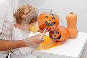 Halloween art craft with kids. Adorable toddler painting together with his dad. Family holiday preparation, party decor