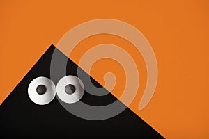 Halloween background, black ghost with bulging eyes on a orange