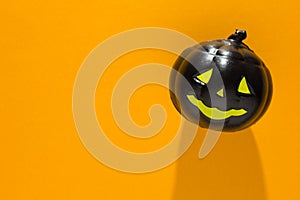Halloween background concept. Detail of black jack O pumpkin face graphic shadow on orange table