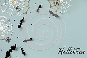 Halloween background with decorations from bats and spider webs with confetti and ribbon. Greeting card with text Happy halloween