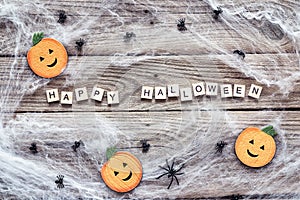 Halloween background with decorative pumpkins, creepy web and spiders on old wooden boards.