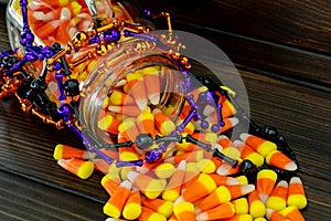 Halloween background frame consisting of a jar full of candy corn on a dark wooden table with a black table that you can personali