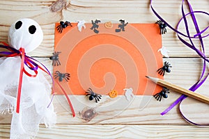 Halloween background. Ghost, bat, pumpkin and spiders on a wooden background with place for text