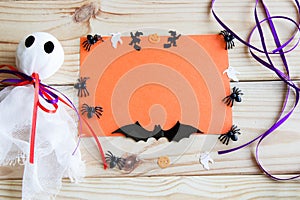 Halloween background. Ghost, bat, pumpkin and spiders on a wooden background with place for text