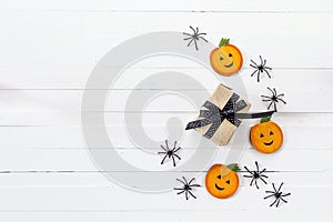 Halloween background with gift box decorative pumpkins and spiders on white boards.