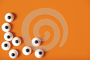 Halloween background, many white bulged eyes on orange background