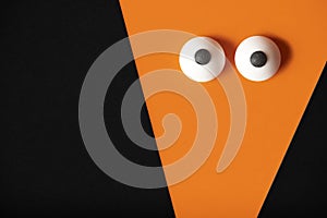 Halloween background, orange ghost with bulging eyes on a black