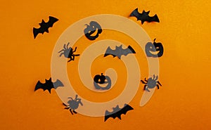 Halloween background, paper black bats, pumpkins and spiders on orange background