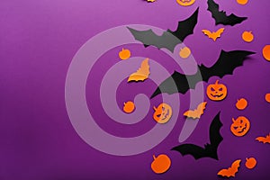 Halloween background with paper pumpkins, Jack O`Lantern, black, orange paper bats flying over purple background, . Copy space.