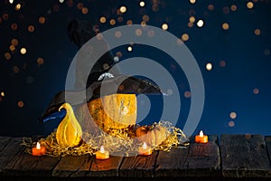 Halloween background with pumpkins, candles on wooden table and bokeh