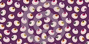 Halloween background. Seamless pattern with eye-shaped lollipops. Vector