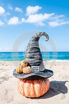 Halloween beach background with witch hat and pumpkins