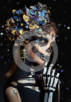 Halloween beauty portrait of a skeleton woman of death Bokeh glitter, the makeup on the face. Girl death Halloween costume. Day of