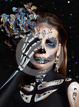 Halloween beauty portrait of a skeleton woman of death Bokeh glitter, the makeup on the face. Girl death Halloween costume. Day of