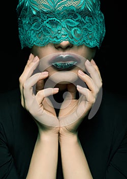 Halloween beauty portrait of young beautiful woman with green lacy ribbon on eyes on black