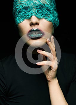 Halloween beauty portrait of young beautiful woman with green lacy ribbon on eyes on black