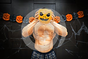Halloween bodybuilder with pumpkin