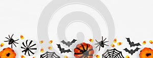 Halloween bottom border banner flat lay of pumpkins, candy and decor, over a white background