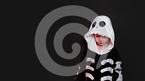 Halloween. boy in a skeleton costume. black background, copy space