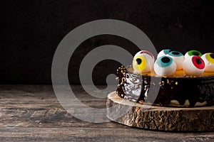 Halloween cake with candy eyes decoration on wood