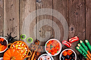 Halloween candy buffet border over a rustic wood background