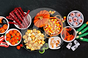 Halloween candy buffet table scene over a black stone background