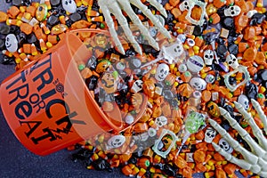 Halloween candy spilling out of orange trick or treat bucket