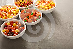 Halloween candy and sprinkles in white bowls