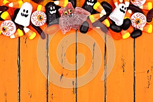 Halloween candy top border over old orange wood