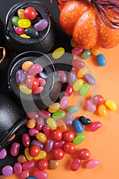 Halloween candy in trick or treat carry cauldrons - vertical closeup.