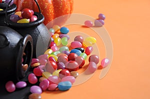 Halloween candy in trick or treat carry cauldrons with witches hat - closeup with copy space.