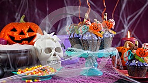 Halloween candyland drip cake style cupcakes in party table setting.