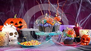 Halloween candyland drip cake style cupcakes in party table setting.