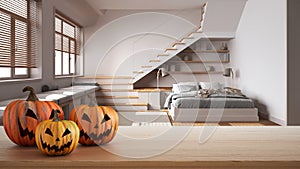 Halloween carved pumpkins on wooden table. Autumn decoration over interior design scene. Modern minimalist japandi bedroom with