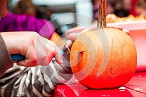 Halloween celebration in the shopping center. Master class for children on carving an evil