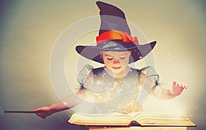 Halloween. cheerful little witch with a magic wand and glowing b