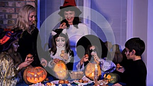 Halloween. Children and parents take refreshments from the festive table.