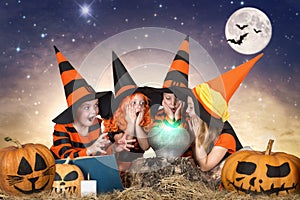 Halloween.The children of witches and wizards cooking potion in the cauldron with pumpkin and spell book. photo