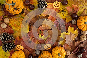 Halloween composition with autumn pumpkins, small Jack-o\'-lantern decorations and fall leaves. Flat lay with copy space.