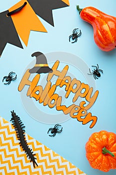 Halloween composition with spiders and pumpkins on blue background. View from above