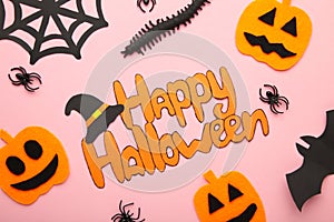 Halloween composition with spiders and pumpkins on pink background. View from above