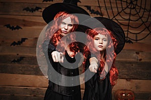 Halloween Concept - Beautiful caucasian mother and her daughter with long red hair in witch costumes with angry fussy