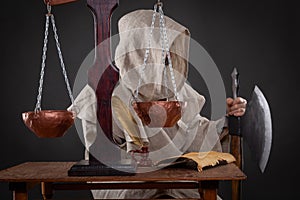 Halloween concept. The executioner of the holy inquisition with ax weighing other people's sins photo