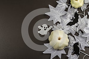 Halloween concept. Ghostly white maple leaves on a branch, pumpkins