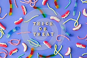Halloween concept. Halloween party decorations with words TRICK OR TREAT, sweets, top view flat lay on blue background