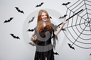 Halloween Concept - Happy elegant witch enjoy playing with broomstick halloween party.