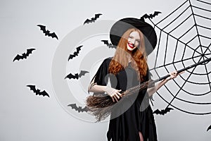 Halloween Concept - Happy elegant witch enjoy playing with broomstick halloween party over grey background.