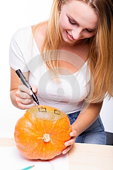 Halloween concept, happy Girl sitting at table with pumpkins pre